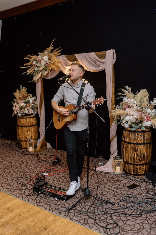 Ben singing and playing guitar at an event